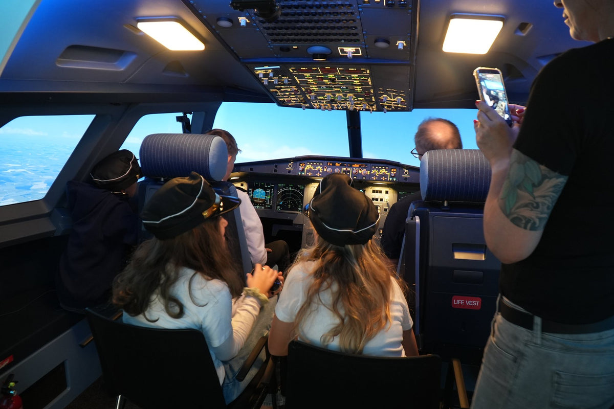Geburtstagsgäste mit Pilotenmützen fliegen im A320 Cockpit bei SkySimWorld