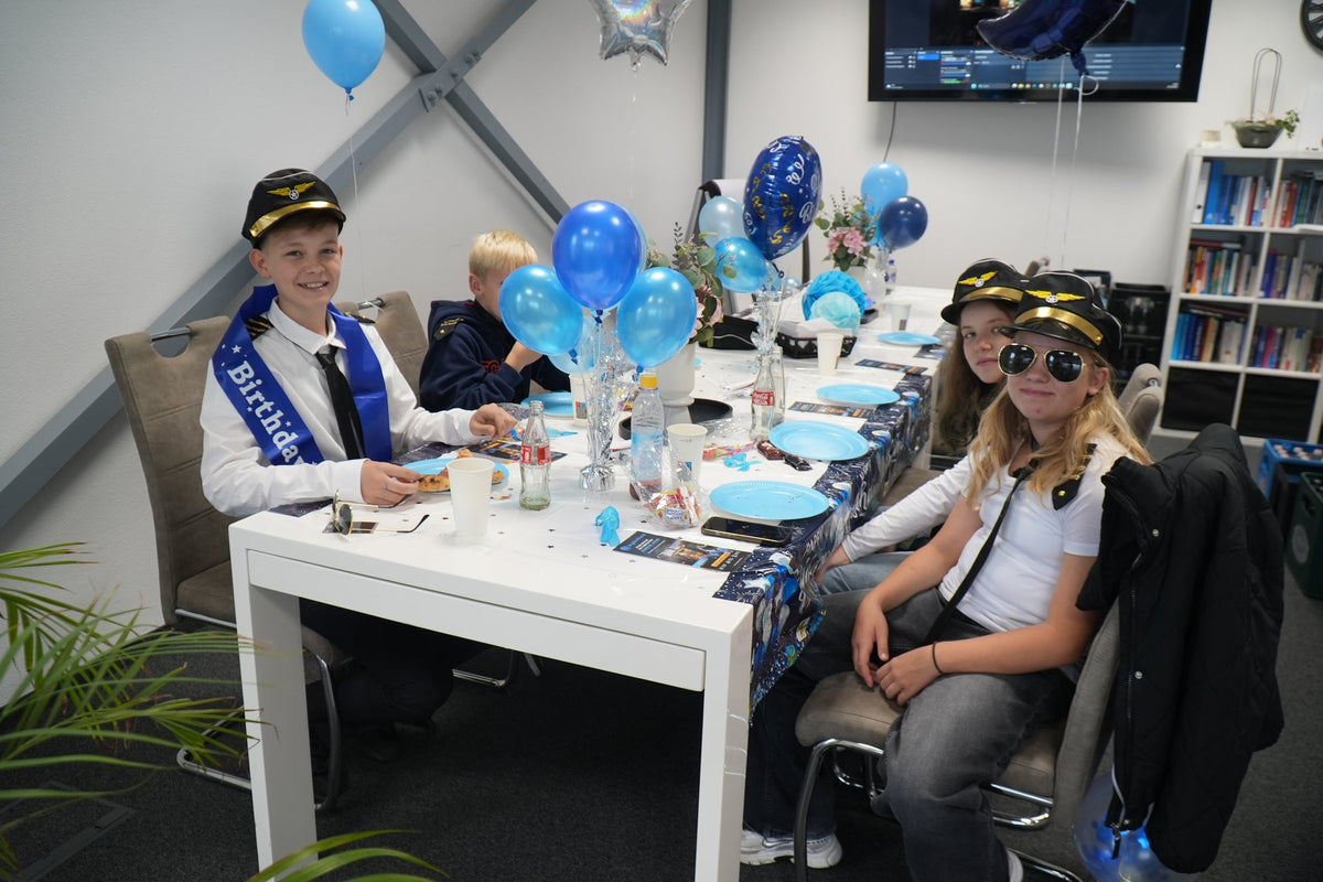 Geburtstagsfeier am Tisch mit Pilotenmützen und Sonnenbrillen bei SkySimWorld
