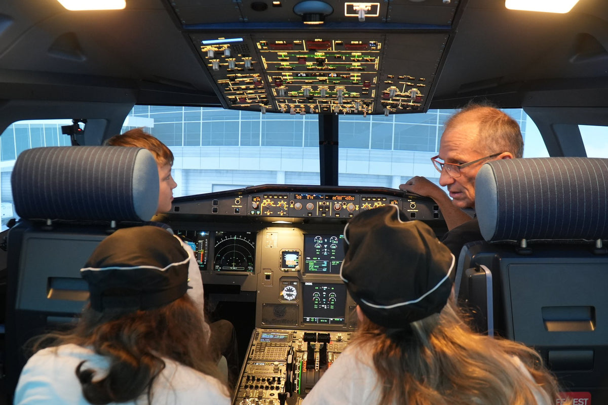 Kinder mit Pilotenmützen im Cockpit des A320 Flugsimulators beim Geburtstag