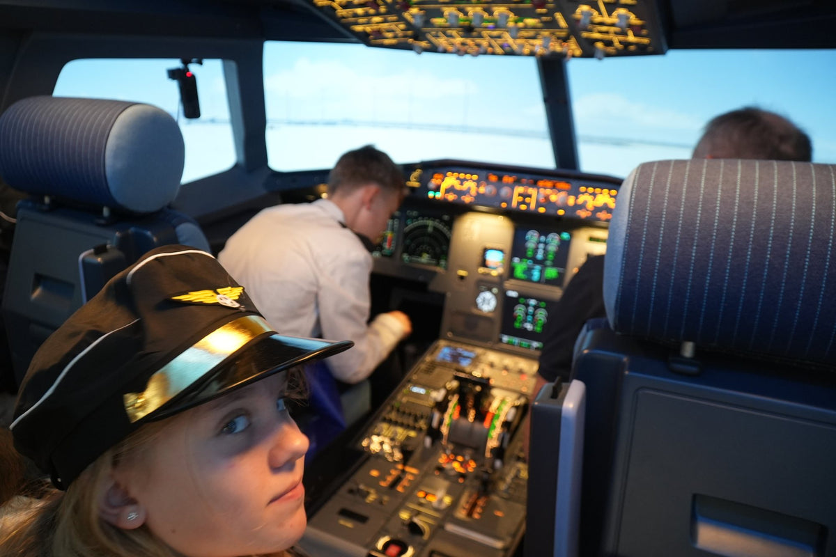 Mädchen mit Pilotenmütze im A320 Cockpit bei SkySimWorld