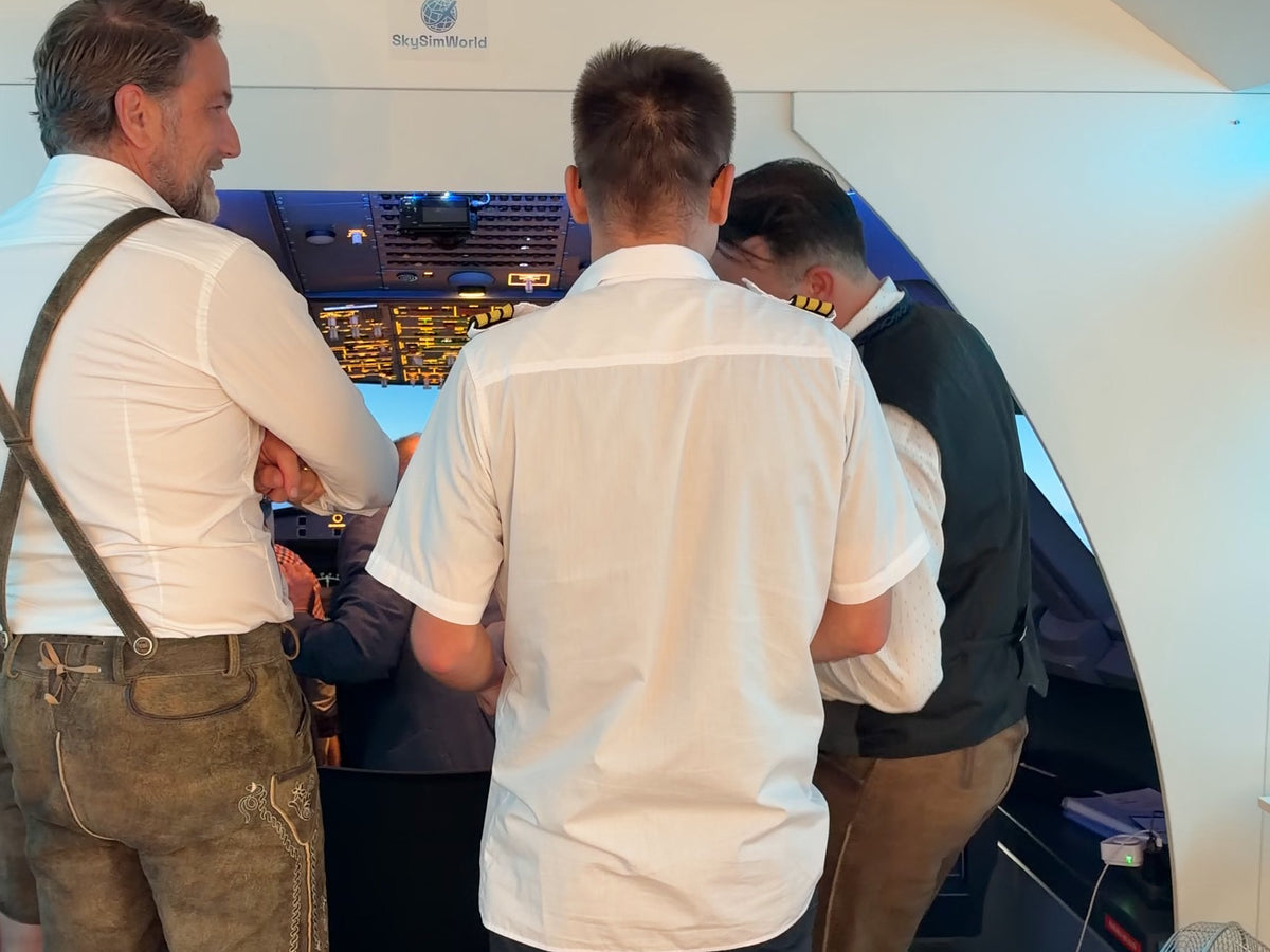 Junggesellenabschied in Lederhosen vor dem Cockpit des A320 Flugsimulators